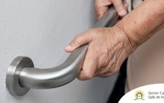 An older adult uses a grab bar representing one of the home modifications that is helpful for fall prevention for elderly adults.